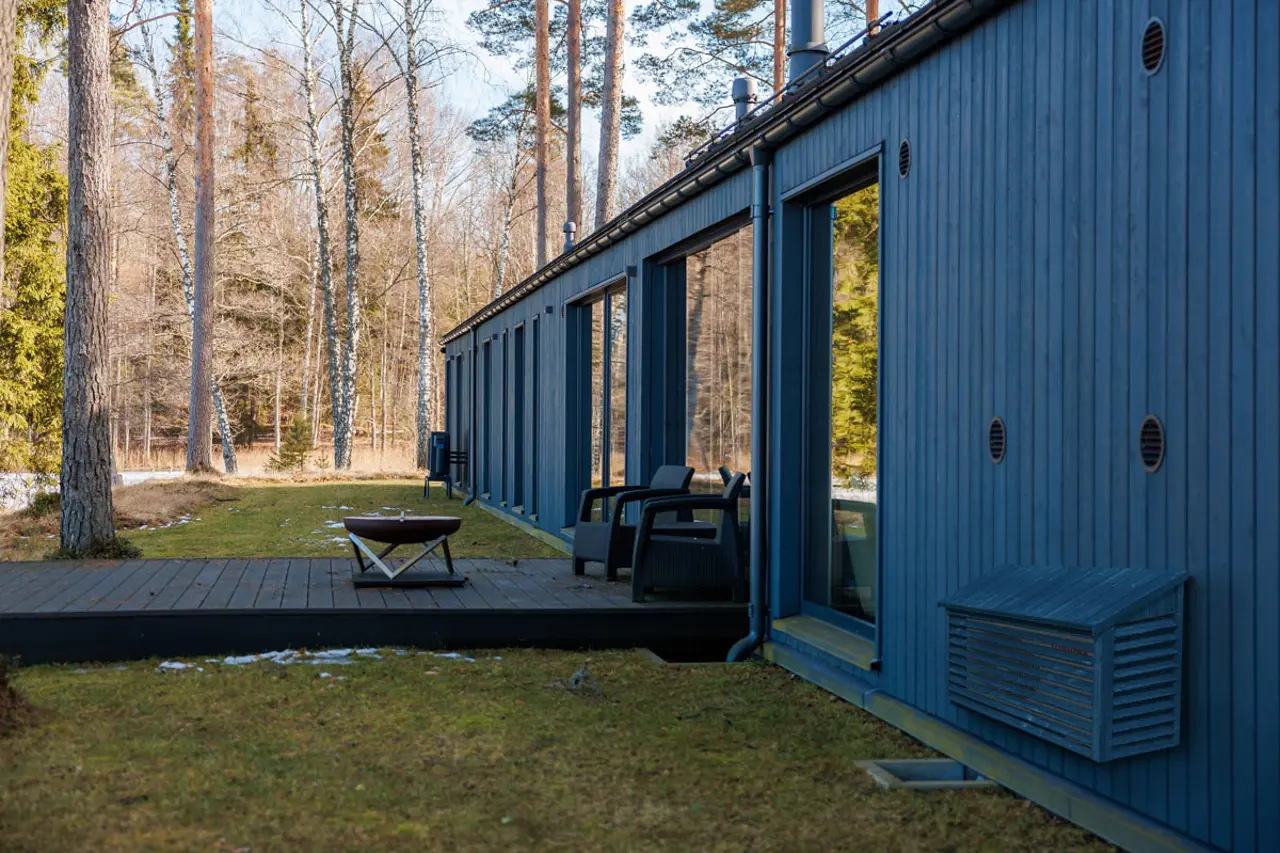 Sortbeiset varmepumpehus i tre, går i ett med fasaden.